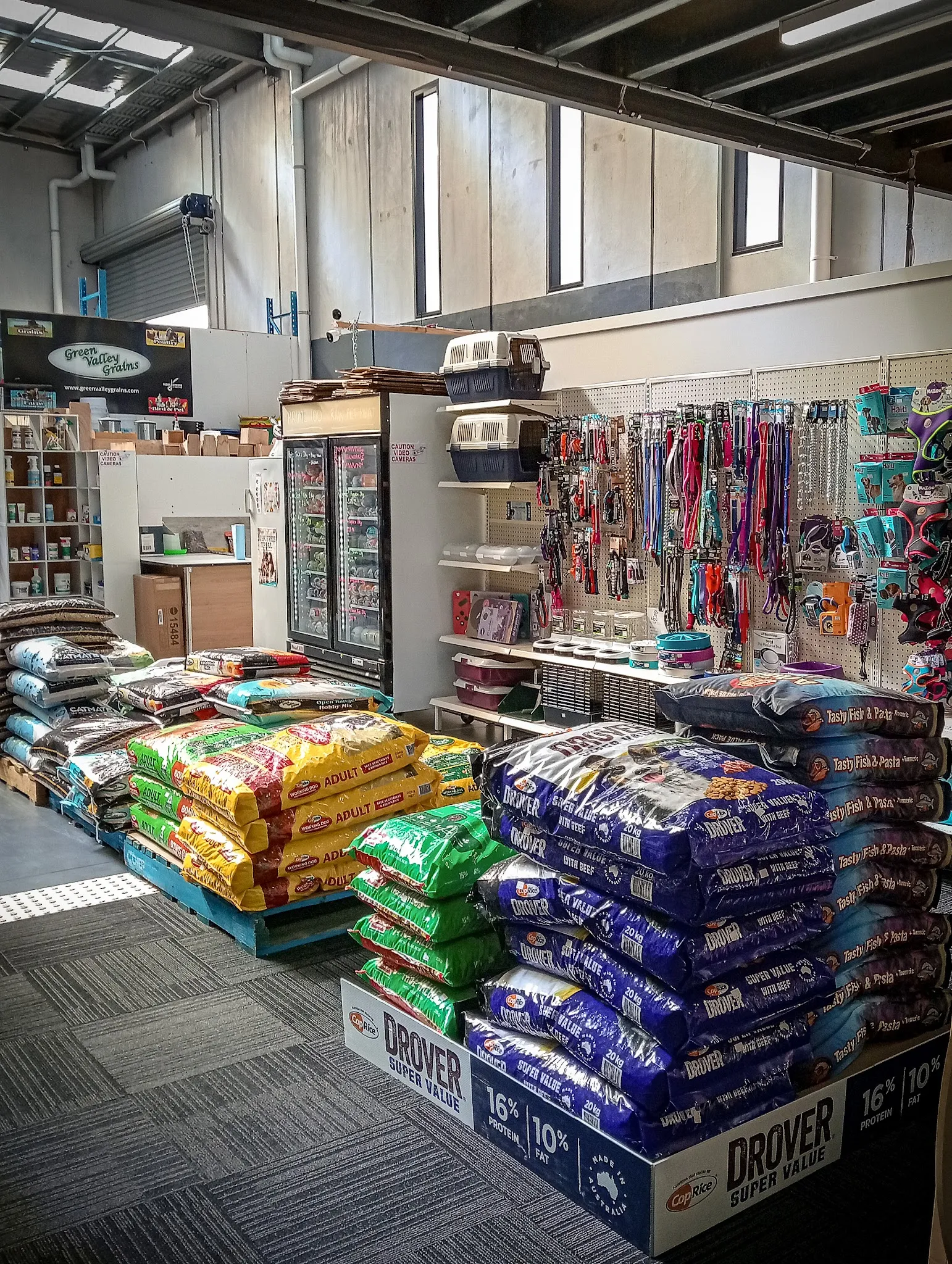 Bass Coast Stock Feeds interior showing stacked pet food bags and pet accessories wall display